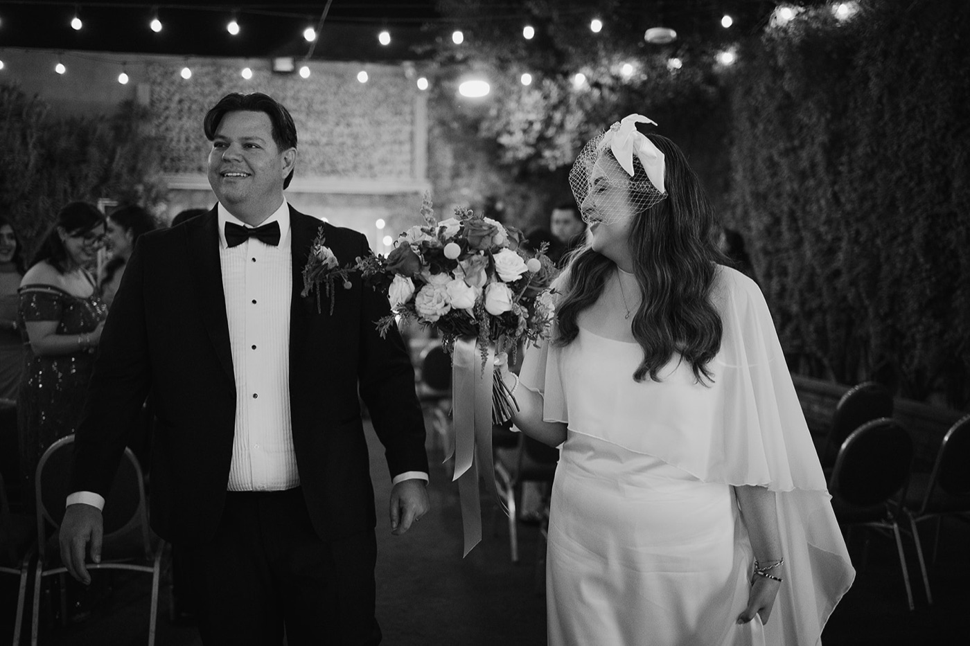 Los novios con el ramo bajo luces cálidas